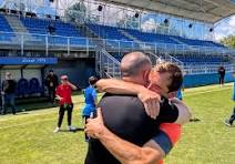 Abrazo en el césped durante la celebración del ascenso